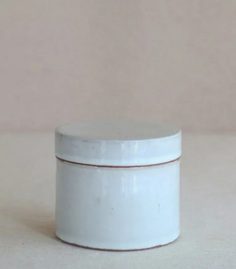 白っぽい釉薬の蓋付き円筒形の陶器容器