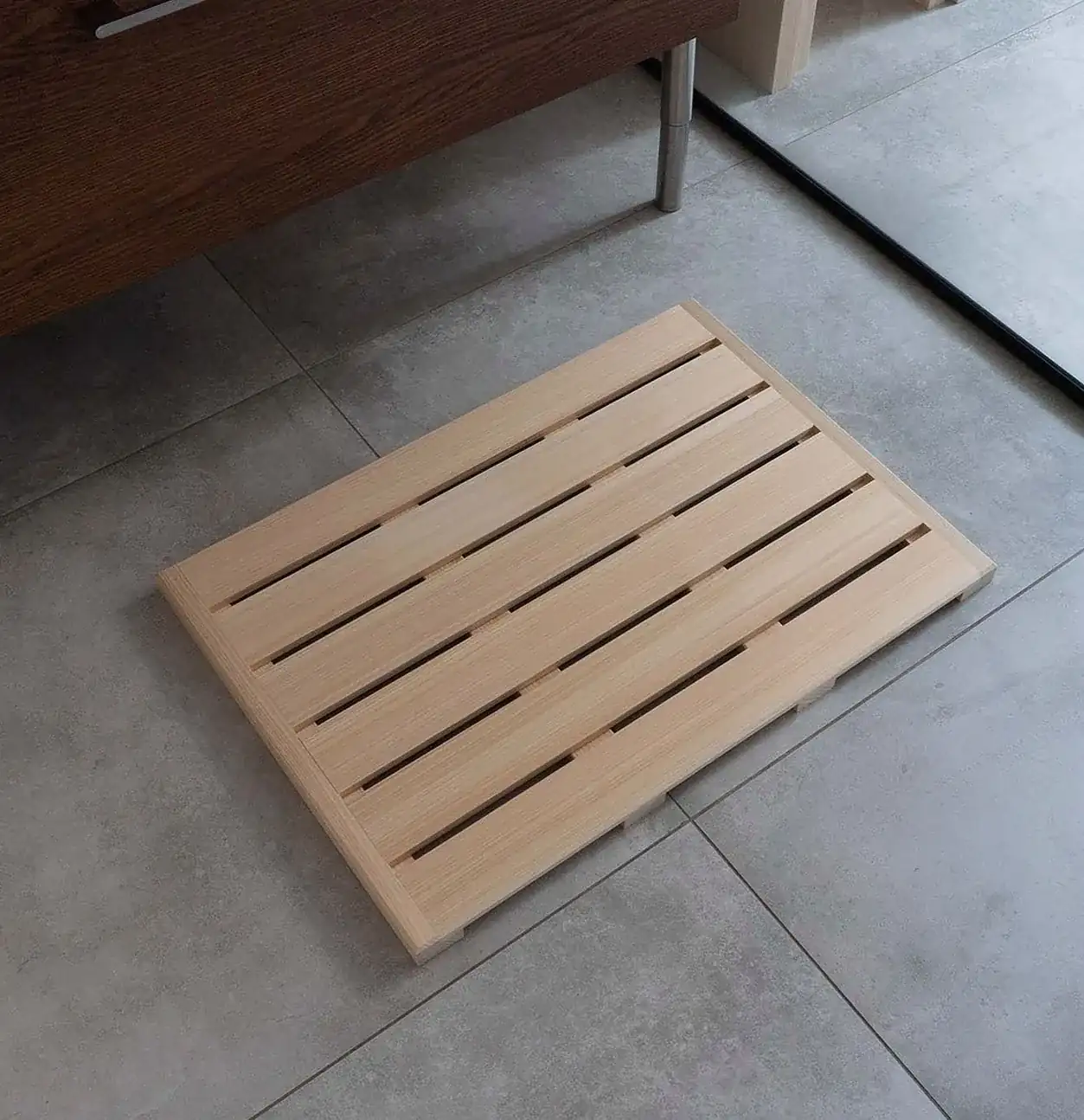 灰色の床の浴室に置いたヒノキのバスマット