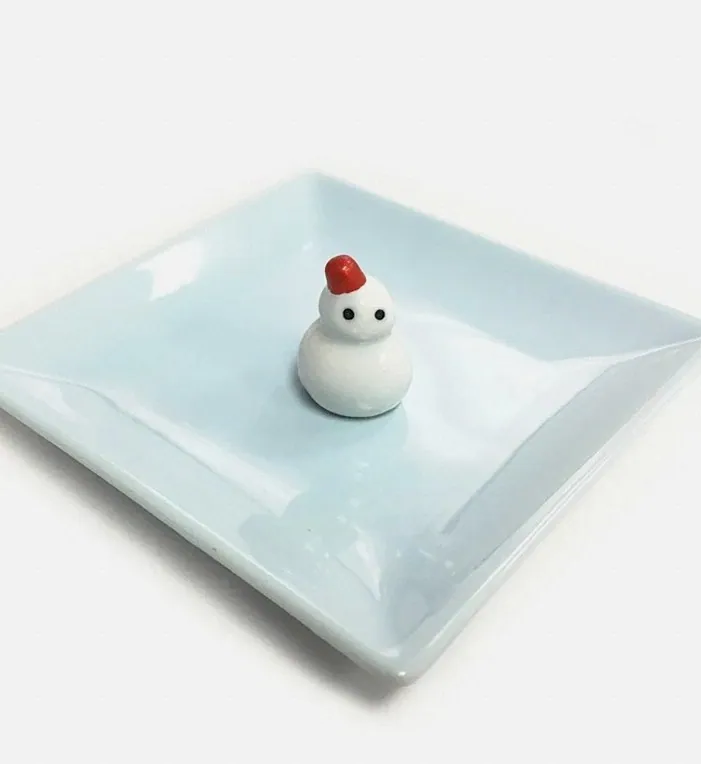 淡い緑色の皿と雪だるまの置物