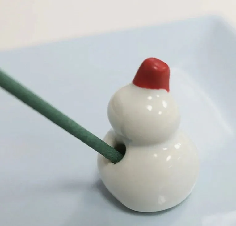 赤い帽子の雪だるまにお香を挿した様子