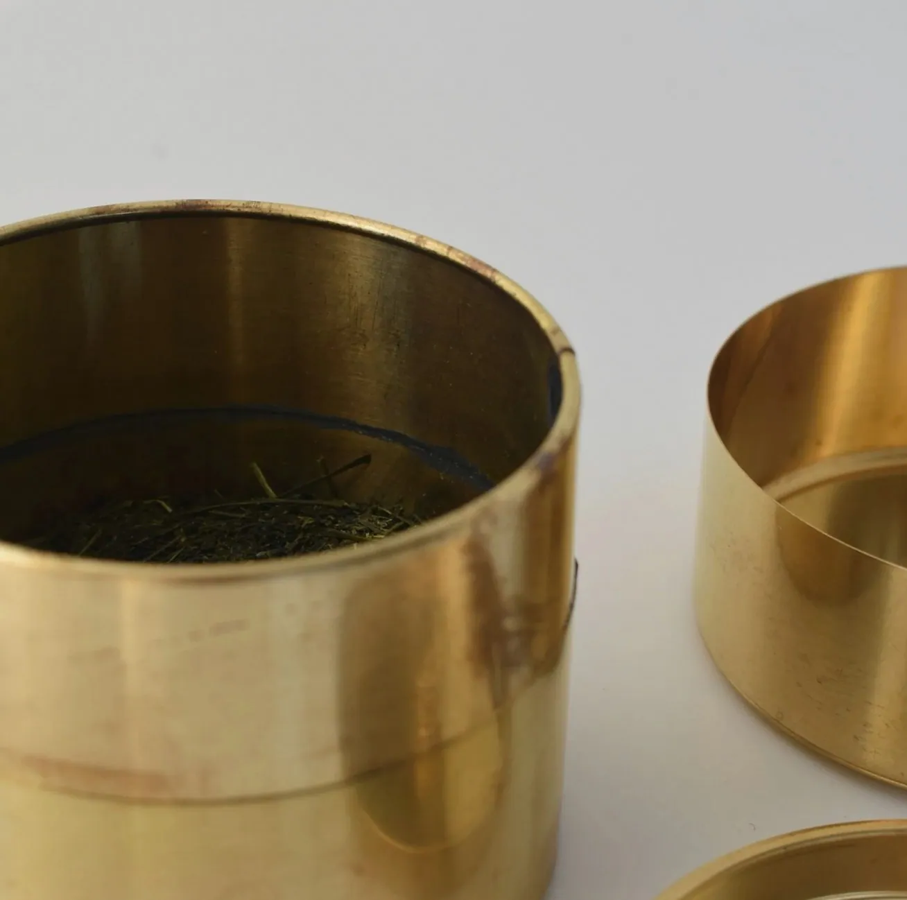 茶葉の入った真鍮の茶筒のアップ